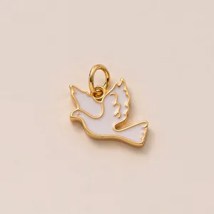 Detailopname van een witte emaille duif vogel hanger met een gouden koperen afwerking