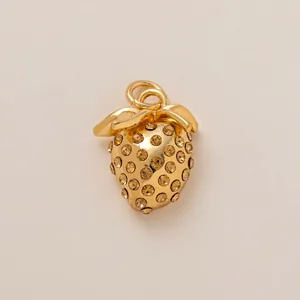 Detailed view of a gold-plated strawberry shoe charm with sparkling amber rhinestones.