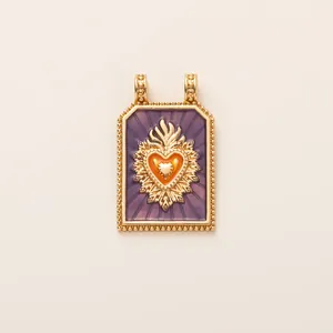 Detailed view of a vintage sacred heart pendant with purple enamel and gold finish