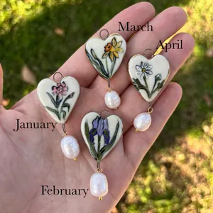 Detail of birth flower heart pendants with baroque pearls for January to April charms.