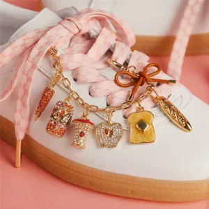 Detail view of sparkly DIY shoe charms featuring butter toast, baguette, and carrot designs.
