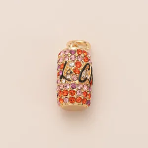 Detail of a pill-shaped shoe charm with colorful rhinestones and black Love script.