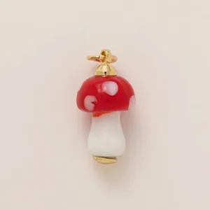 Détail d'une breloque champignon rouge à pois blancs et attaches dorées