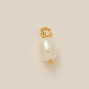 Détail d'un élégant pendentif en perle ovale blanche avec un anneau en acier plaqué or 18 carats