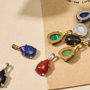 Macro detail view of teardrop gemstone pendants in gold and silver plated titanium steel