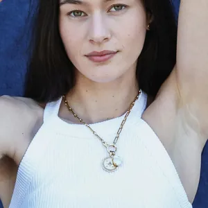Detail of titanium steel 18k gold necklace with teardrop gem and star pendant on model