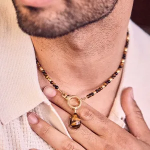 Close-up of tiger's eye bead necklace with teardrop pendant and handcuff clasp