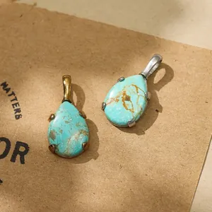 Close-up of teardrop turquoise pendants in gold and silver stainless steel settings
