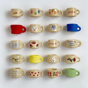 Set of 20 miniature ceramic-style cup charms for DIY jewelry making in various cute patterns.