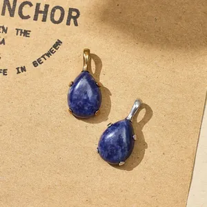 Detailed macro view of teardrop blue gemstone pendants with gold and silver steel bases.