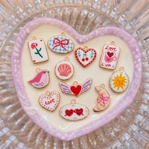 Detailed view of colorful stainless steel charms with heart, sun, and bird motifs.