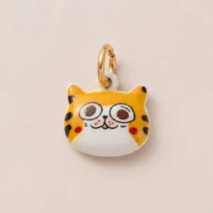 Vue macro d'un joli pendentif chat de dessin animé pour bijoux DIY avec anneau en or 14K.