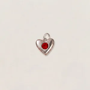 Primo piano di un ciondolo a cuore in acciaio inossidabile con cristallo rosso