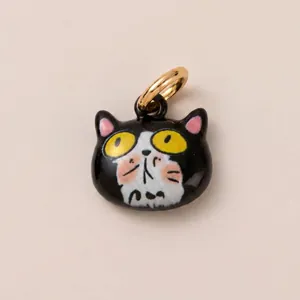 Détail d'un pendentif de chat de dessin animé noir et blanc avec un anneau doré