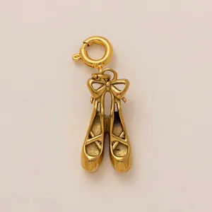 Détail d'un pendentif en forme de ballerines en acier inoxydable plaqué or 18K.
