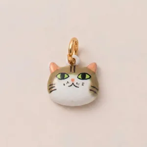 Gros plan d'un pendentif chat de dessin animé avec yeux verts et anneau en or 14K pour bijoux