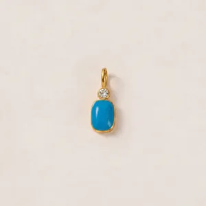 Dettaglio del ciondolo in acciaio placcato oro 18K con pietra blu e cristallo trasparente.
