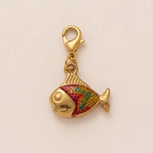 Dettaglio di un ciondolo a forma di pesce d'oro con smalto colorato per gioielli
