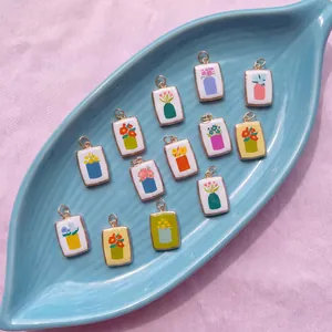 Vue détaillée de divers pendentifs floraux avec motifs de tulipes et roses sur plateau.