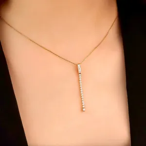 Elegante primo piano di una collana placcata in oro con ciondolo a barra di diamanti