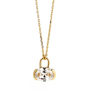 Primo piano di una collana di lusso placcata in oro con pendente a lucchetto e diamante sagomato.
