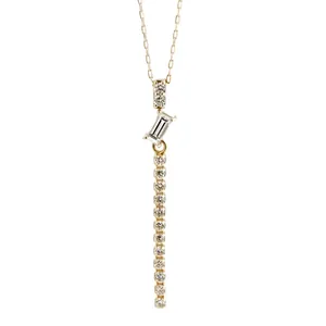 Primo piano della collana placcata oro con pietra baguette e nappa di diamanti brillanti.
