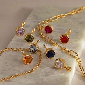 Vue détaillée de pendentifs hexagonaux en pierres de naissance sur chaînes dorées