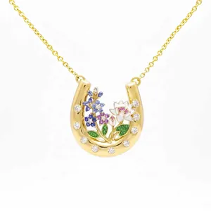 Detailed view of a golden horseshoe necklace with intricate colorful floral inlay
