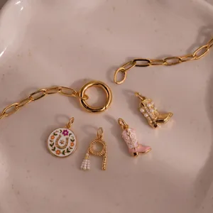 Detailed view of cowboy themed charms including boots and horseshoe with pearl accents