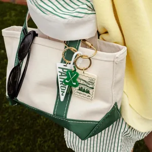 Set of golf themed bag charms on a canvas tote bag in a lifestyle setting