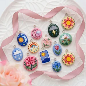 Detailed view of colorful hand-painted ceramic pendants with nature and floral motifs