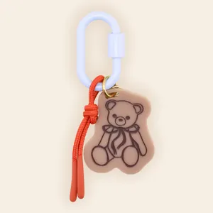 Detailed close-up of a cute cartoon bear bag charm with a colorful carabiner clip hook