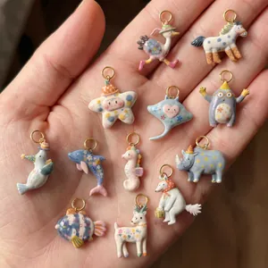 Close-up van diverse kleurrijke keramische dierenhangers vastgehouden in een hand