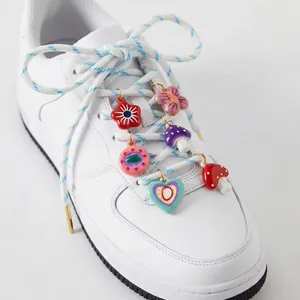 Gros plan de charms DIY en acier inoxydable colorés sur des lacets de baskets blanches