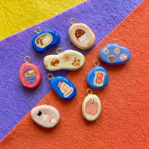 Various food-themed pebble charms featuring sushi and bread designs for DIY jewelry