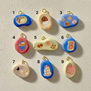 Macro view of nine numbered pebble pendants with hand-painted sushi and bread food designs