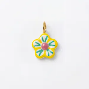 Détail d'un pendentif en forme de fleur en céramique colorée avec un anneau de saut doré
