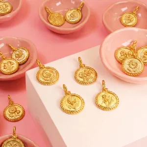 Detailed view of vintage gold coin pendants with embossed birth month flower designs.