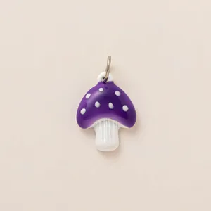 Vue détaillée d'un petit pendentif champignon en émail violet pour bijoux DIY.