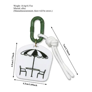 Unique bag charm featuring umbrella illustration tag, green carabiner and white cord accent