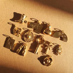 Detailansicht verschiedener goldener Edelstahl-Anhänger für DIY-Schmuck und Schuhe.