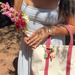 Detailed view of hand-painted fruit and vegetable charms on a stylish canvas bag