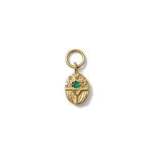 Close-up of a vintage gold-plated stainless steel oval pendant with a green zircon