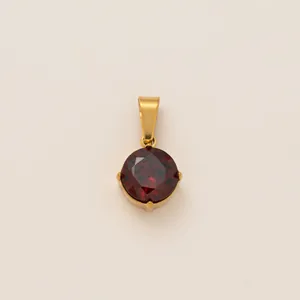 Gros plan d'un pendentif rond en pierre rouge plaqué or 18 carats.