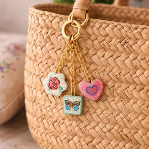 Gros plan de pendentifs en céramique peints à la main avec rose papillon et motifs de cœur