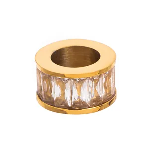 Gros plan d'un pendentif cylindrique en acier inoxydable plaqué or 18 carats avec cristaux.