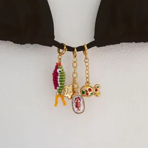 Gros plan détaillé de breloques pour bikini style marin avec poisson et pendentif homard.