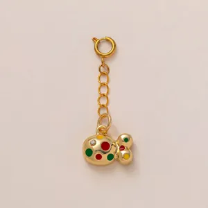 Vue détaillée d'un pendentif poisson doré avec des points en émail multicolores vibrants