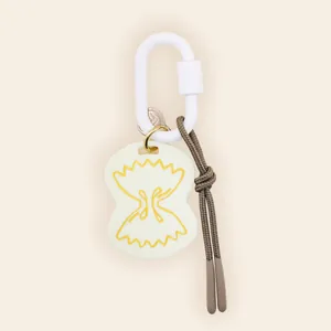 Detail of farfalle pasta shaped bag charm with white carabiner and brown cord