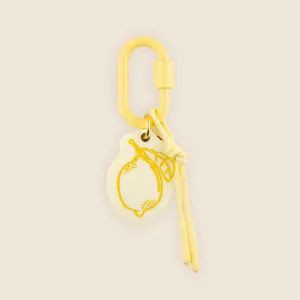 Detailed close-up of a hand-drawn lemon keychain pendant with yellow carabiner